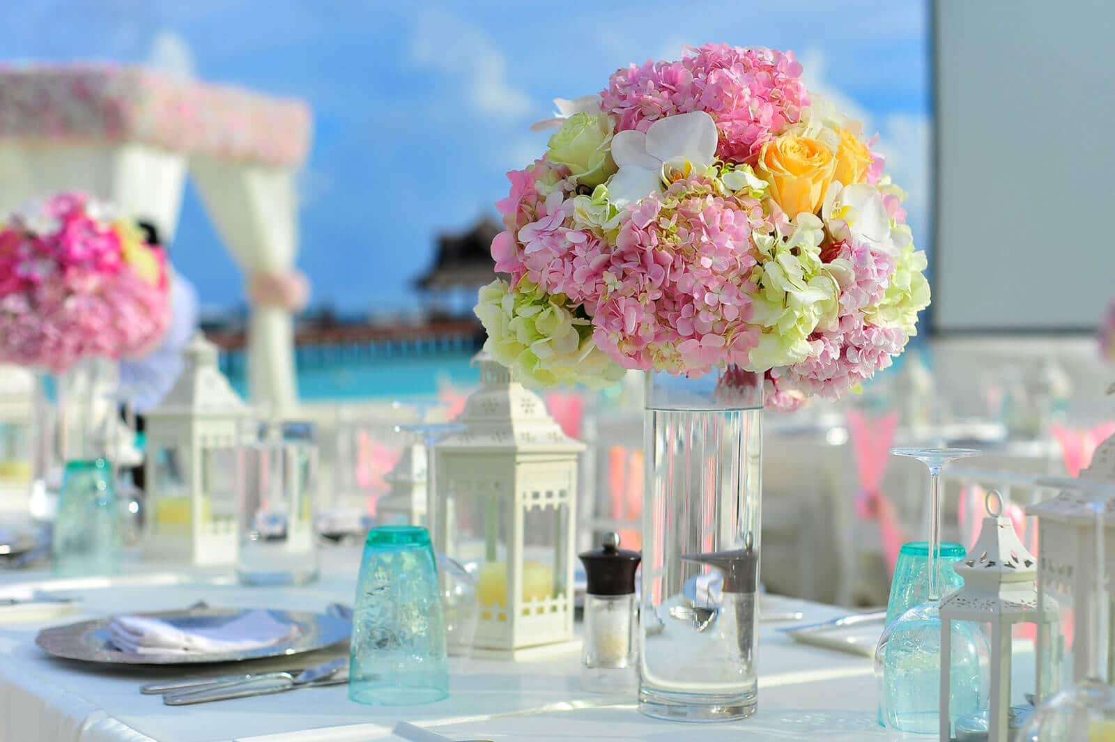 Table set with dishes and silverware and vases with colorful bouquets