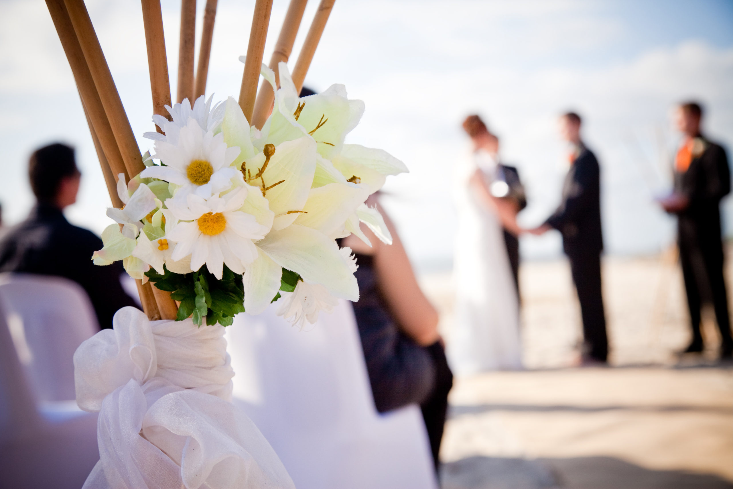 Beach Wedding Flowers with Bride and Groom in the background